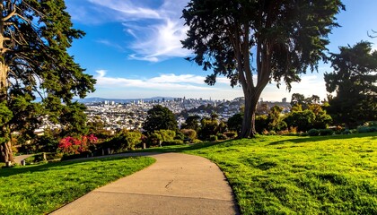 Obraz premium A winding path through a park, overlooking a distant cityscape under a bright blue sky with scattered clouds. Green trees frame the view