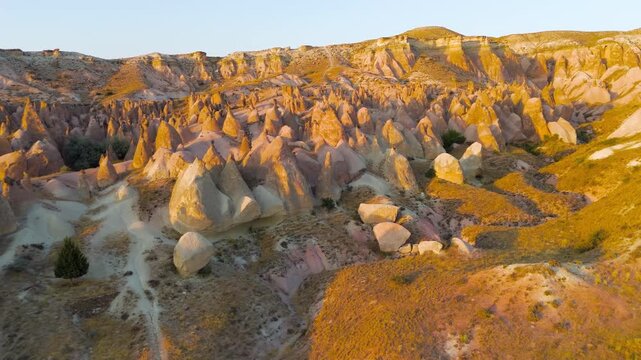 Goreme, Nevsehir, Turkey. Inspiring aerial view of Devrent Valley with magical rock formations and golden sunset colors. Aerial View