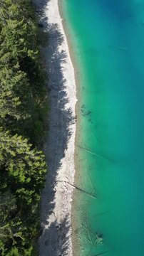 Lake Cauma shore, clear clean shallow turquoise water Switzerland aerial drone vertical video