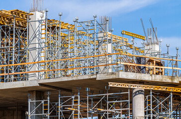 modern concrete building frame under construction with scaffolding and beams.
