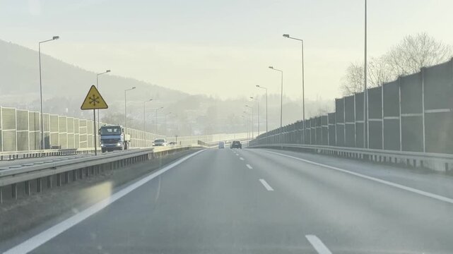 Curved highway with sound barriers in misty morning