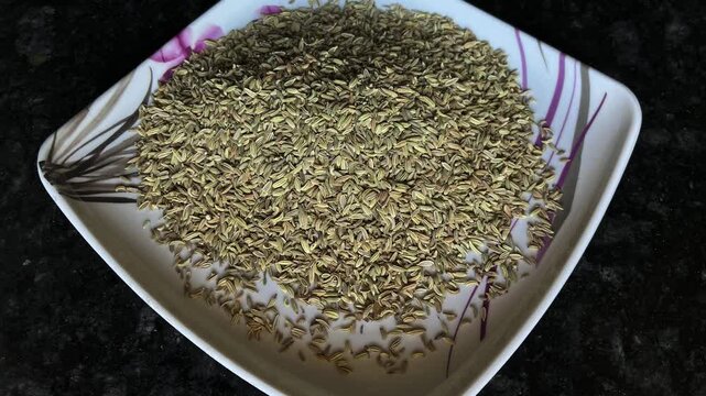 Top view of high-quality fresh organic cumin seeds (Jeera) served on a white decorative plate