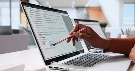 Obraz na płótnie Canvas African-American Woman Editing Documents On Computer