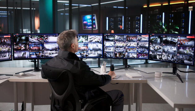 Caucasian Man Monitors Multiple Surveillance Cameras For Enhanced Security