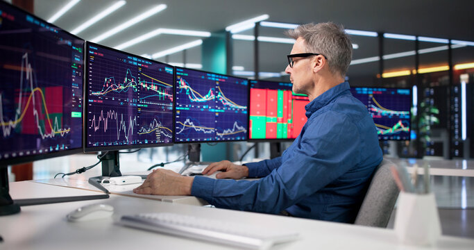 Experienced Trader Analyzing Market Trends On Computer Screens
