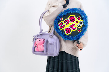 推し活うちわとぬいぐるみの入ったバッグを持った女子学生