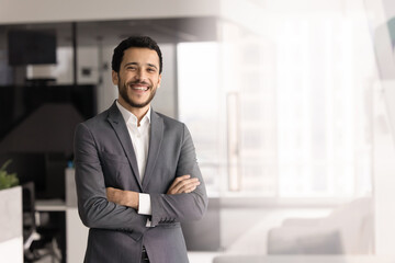 Fototapeta premium Successful Arab businessman, male entrepreneur, professional staff member in elegant suit posing in contemporary highrise building office, exuding professionalism and competence. Company boss portrait