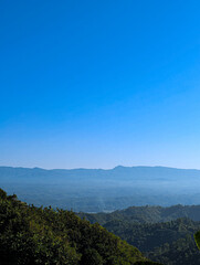 Fototapeta premium Breathtaking Mountain Landscape with Lush Green Tropical Forest and Clear Blue Sky