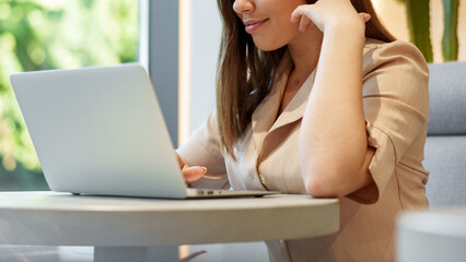 Woman using laptop in a modern cafe during daytime