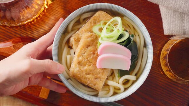 大きな油揚げにかまぼこを添えたきつねうどん
