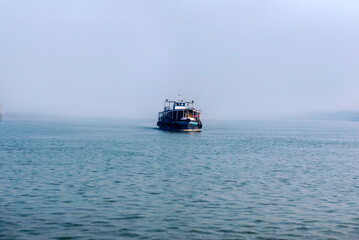 Passenger ferry coming over blue sea and sky horizon