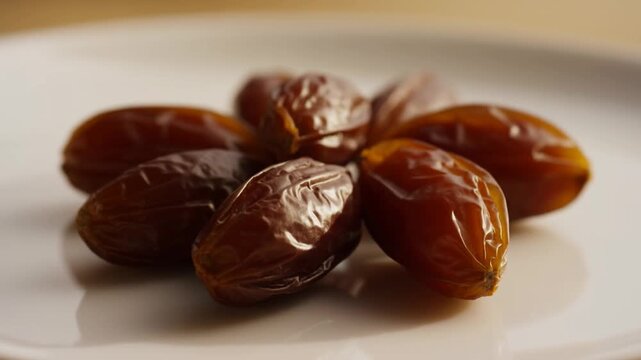 A close-up of several ripe, golden-brown dates neatly arranged on a white background. Suitable for Ramadan, healthy eating, breaking the fast, and Islamic themes, with soft lighting and a focus on det