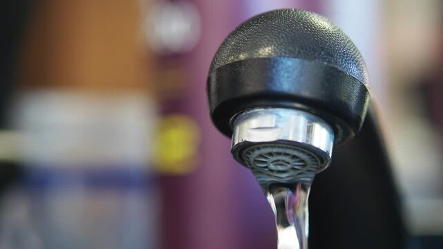 Water flowing from a tap in a kitchen at home