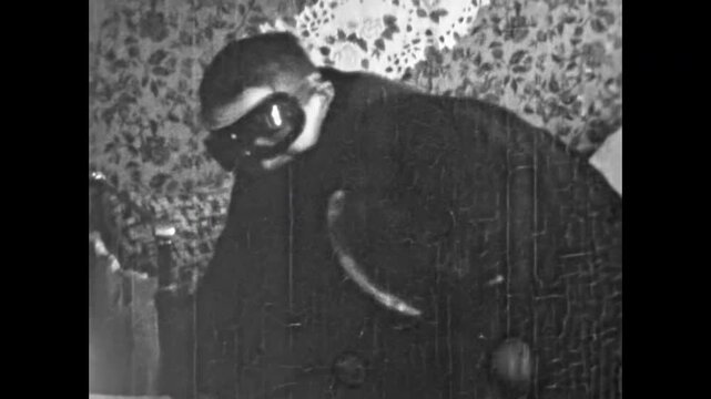 Two retro-style gangsters engage in dramatic confrontation in apartment. Black and white noir film. Crime mafia, mafia culture, action parodies. Old gangster vintage archive. Archival retro 1960s