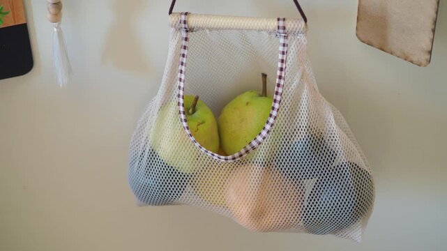 Fresh fruit in a mesh bag on a wall hook