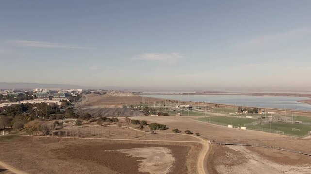 Stunning aerial view of the vibrant San Francisco Bay wetlands and salt ponds near South San Jose. Cinematic 4K drone footage showcasing the unique natural colors of the Alviso coastal marshes.