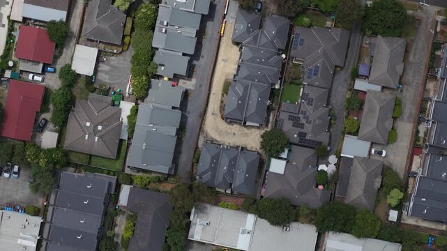 Drone footage capturing the structured layout of suburban homes in Boronia, Melbourne. Overhead view reveals vibrant rooftops, lush greenery, and residential architecture. Unique urban scene.