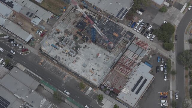 Aerial footage showcasing a bustling construction site with cranes at work in Boronia, Melbourne, under clear skies, highlighting urban development and industrial progress.