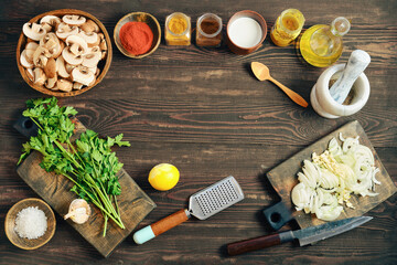 Ingredients and tools for cooking on wooden table with spices and vegetables