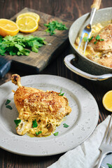 Chicken dish served with lemon and herbs on a table with fresh ingredients nearby