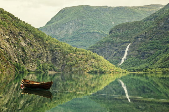 Wooden Rowboat on Calm Eidsvatnet Lake with Waterfall Reflection