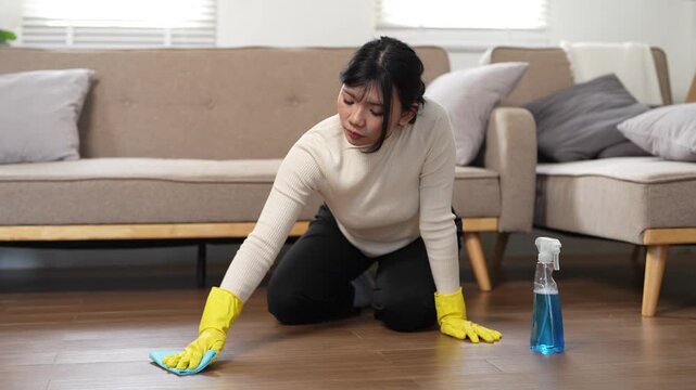 Cleanliness, asian young woman work chore cleaning on floor at home, hand wearing glove using wiping cloth remove dust with spray bottle. Household hygiene clean up, equipment tool for cleaning
