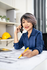 Civil Engineer working on shop drawings of  post tension slab plan on desk talking on phone call...