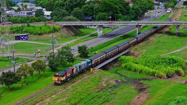 Kuranda Scenic Railway train winding through green tropical countryside near Cairns aerial landscape