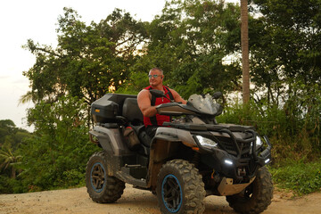 Fototapeta premium A man engages in extreme ATV riding on mountains in the evening