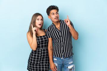 Naklejka premium Teenager caucasian couple isolated on blue background thinking an idea pointing the finger up