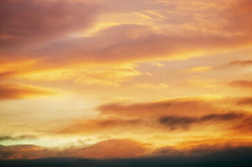 Fototapeta premium Dramatic sunset sky with vibrant orange and yellow clouds creating a beautiful natural spectacle