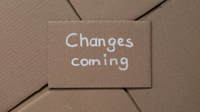 Cardboard with handwritten words Changes Coming on a cardboard pieces background