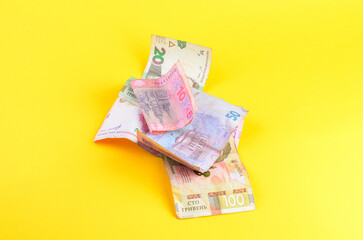 Obraz premium Pile of Ukrainian Hryvnia banknotes scattered on a bright yellow background