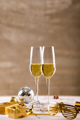 Closeup of champagne flutes by golden novelty glasses and gift boxes on table