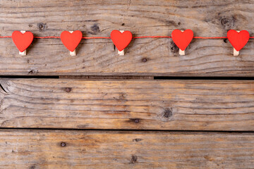 Overhead shot of red heart shaped decoration with copy space on wooden table