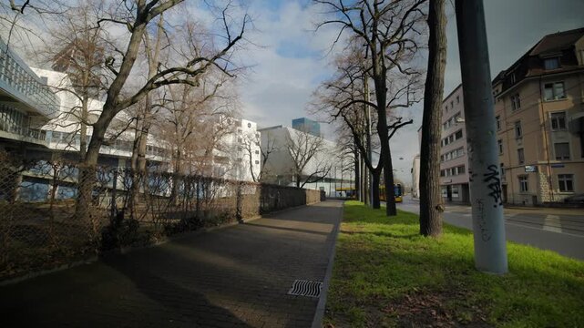 Panning shot of the urban industrial area at Riehenstrasse in Basel, Switzerland, showing the steel bridge structure, street infrastructure, and city surroundings.