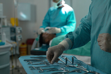 Midsection of male surgeon preparing surgical instruments in operating theatre at hospital