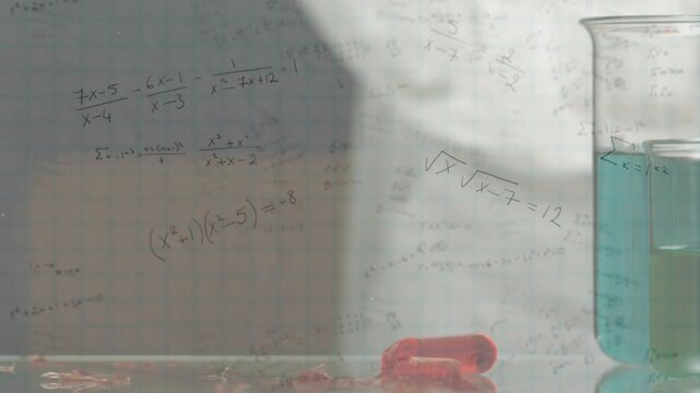 Red capsule falling onto glass, hitting, rupturing, fragments scattering outward to show fragility