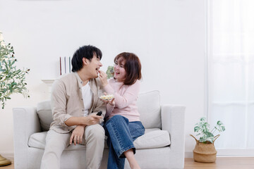 Couple ebjoy eating popcorn while watching movie