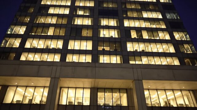 Modern office building with illuminated windows at night in a city