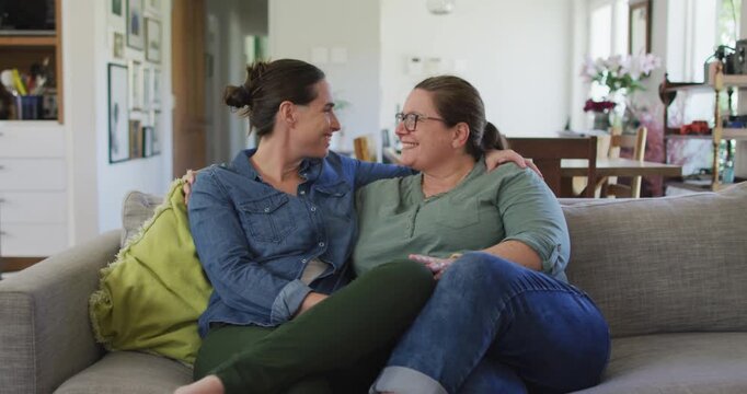 Portrait of caucasian lesbian couple looking at camera, embracing