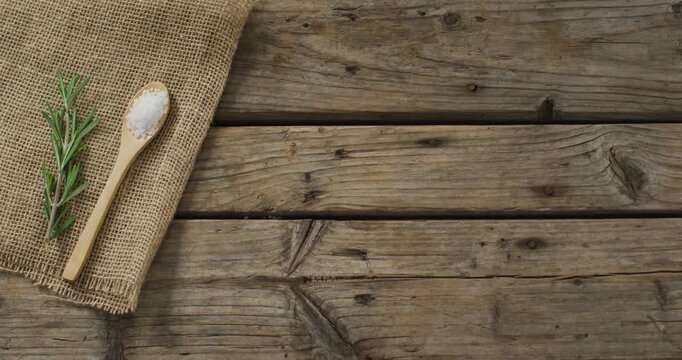 Video of rosemary twig and spoon of salt on wooden background