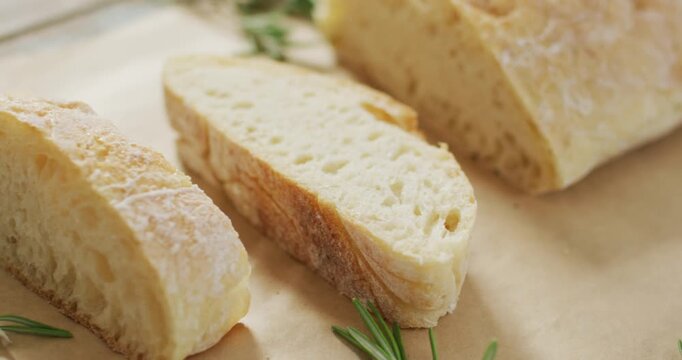 Video of rosemary and brad on baking paper on wooden worktop