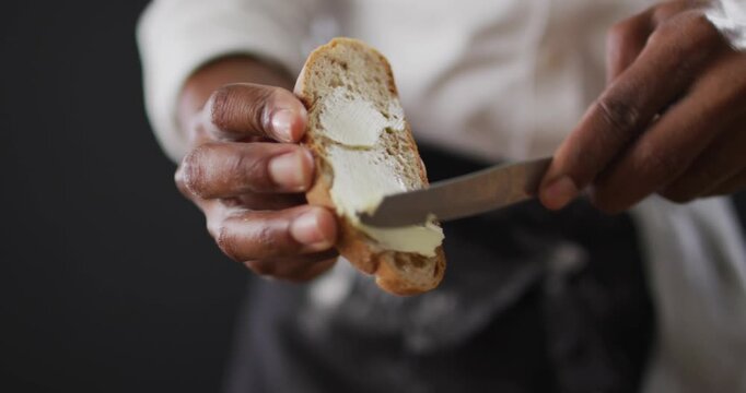 Video of cook grease bread with butter on black background