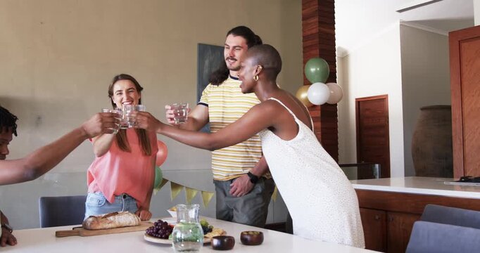 Friends celebrating at home, toasting with drinks and enjoying festive gathering