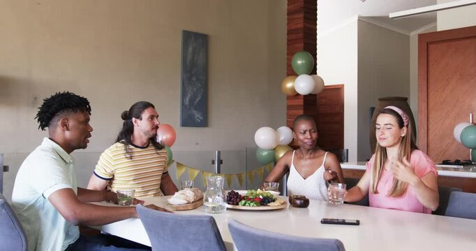 At party, Friends enjoying lunch together, smiling and taking selfie at dining table