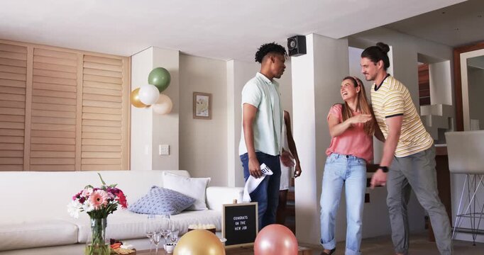 At party, Friends celebrating new job at home, placing sash on smiling woman