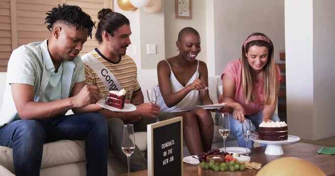 Celebrating new job, diverse friends enjoying cake and laughter at home party