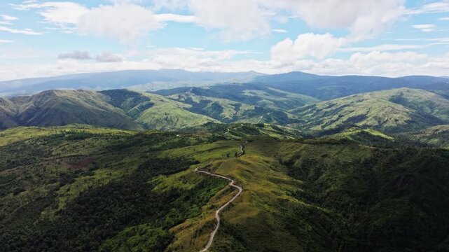Drone slowly flies forward, green mountains in Aguilar Pangasinan sunny clouds