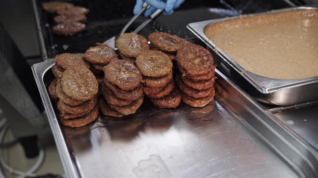 Stacked meat patties on serving tray.